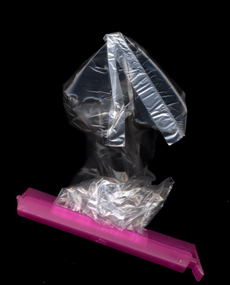A plastic bag filled with water, secured with a pink clip